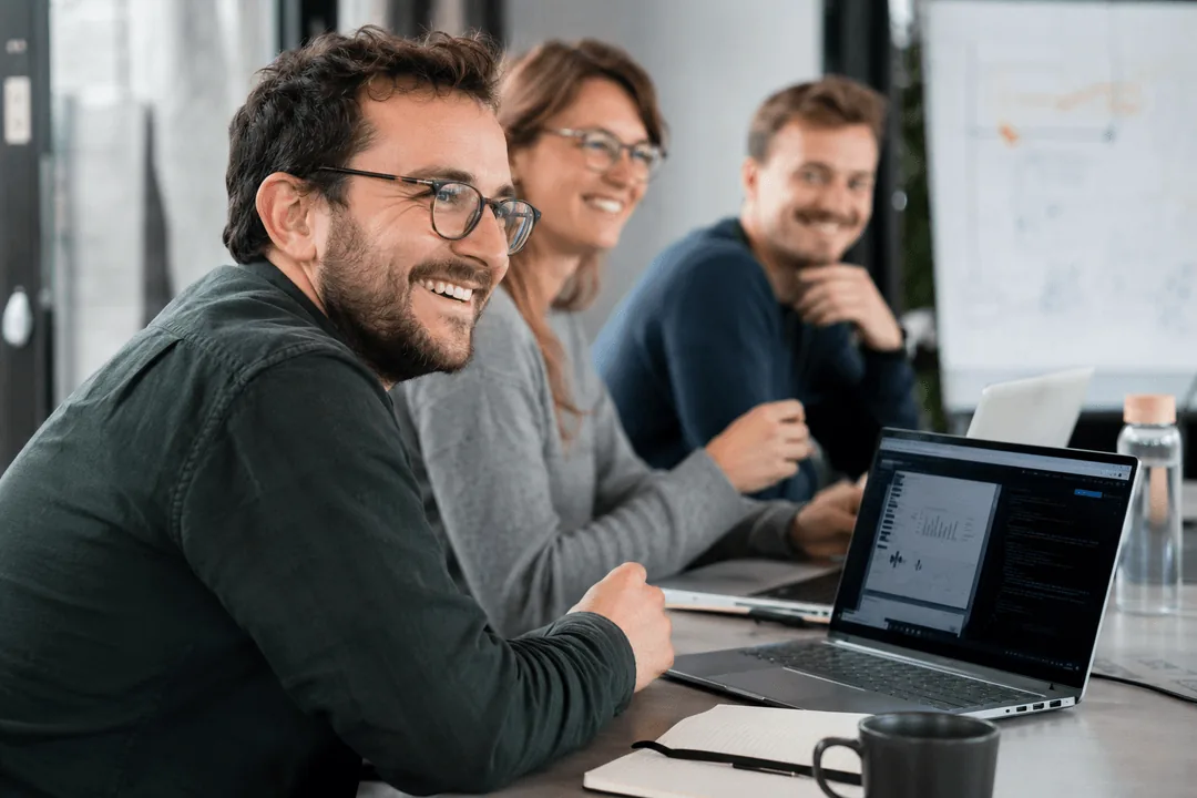 Teilnehmende der KI & Leadership Weiterbildung arbeiten gemeinsam am Laptop